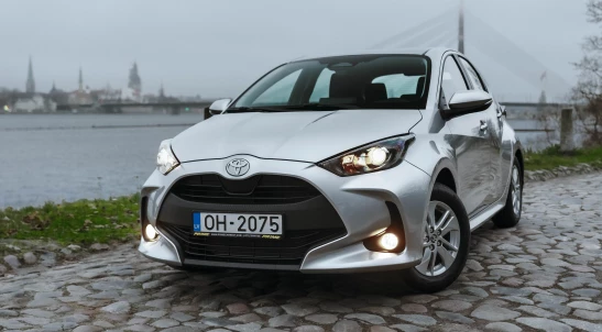 Toyota Yaris Hybrid rental car parked by the river in Riga, Latvia